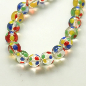 Close-up of transparent glass beads with colorful rainbow polka dots for DIY jewelry