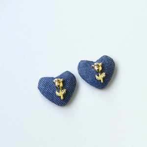 Close-up of heart-shaped blue polka dot denim patches with gold rose ornaments