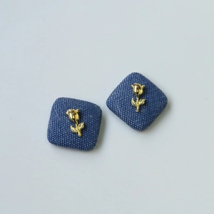 Detailed view of denim heart button with golden rose ornament for DIY crafts