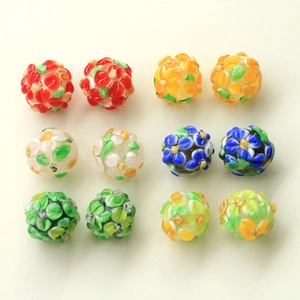 Flat lay of twelve colorful handmade millefiori glass flower beads for DIY jewelry making