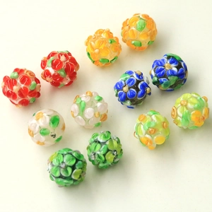 Macro detail of handmade colorful lampwork glass floral beads for DIY jewelry crafting