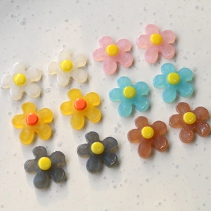 Close-up of colorful resin flower charms with smooth matte finish for DIY jewelry crafts