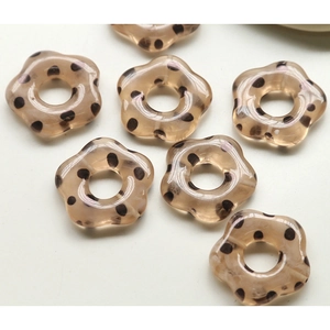 Vue macro de perles fleurs en acrylique marron à pois pour la création de bijoux DIY