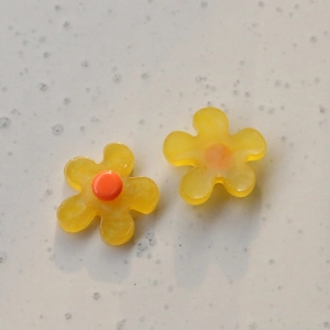 Detailed macro of yellow flower resin beads for DIY earring and hair accessory making