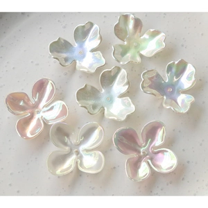Macro view of iridescent four-leaf clover beads with a pearlescent finish for DIY jewelry