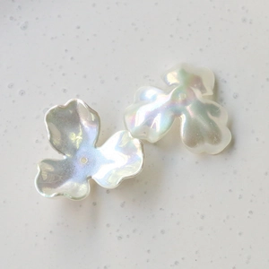 Macro shot of iridescent white three-petal flower beads for DIY jewelry and crafts