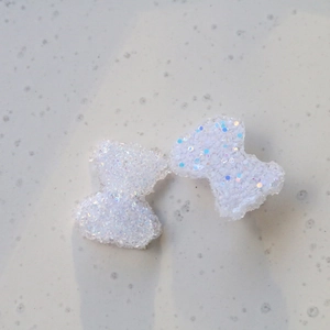 Dettaglio di fiocchi in resina glitterata per creazione di gioielli e accessori DIY
