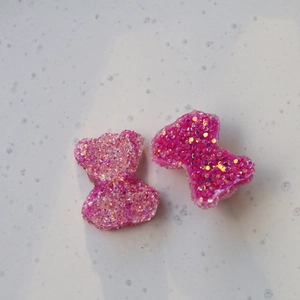 Dettaglio di orsetti in resina rosa con paillettes scintillanti per accessori fai-da-te