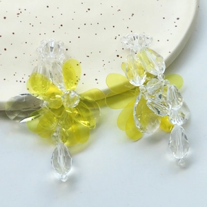 Handmade yellow flower earrings with clear crystal beads and resin petals in a ceramic dish