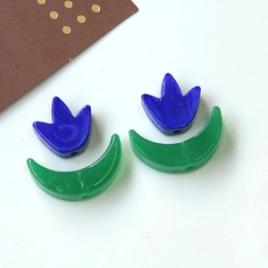 Dettaglio di perle di vetro a petalo blu e luna verde con fori per gioielli DIY