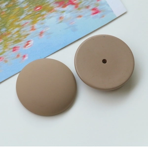 Macro detail of matte brown round resin beads with a smooth finish and a single center hole
