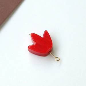Dettaglio pendente a petalo rosso con perno dorato per creazione di gioielli fai-da-te