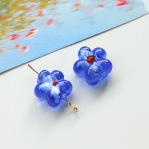 Macro shot of handmade blue glass flower bead with red core for DIY jewelry making