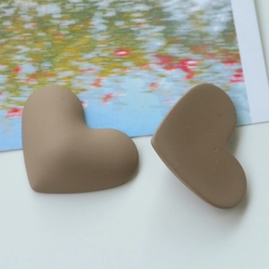 Macro detail of 3D heart-shaped matte resin charms in brown for DIY jewelry making
