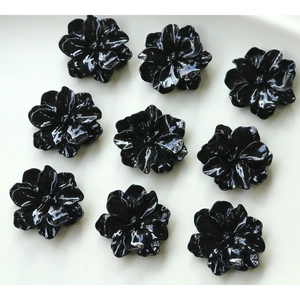 Macro shot of 3D layered black resin flower charms with mirror finish for DIY crafts