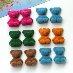 Flat lay of colorful flocked bear charms for DIY jewelry and phone case decoration