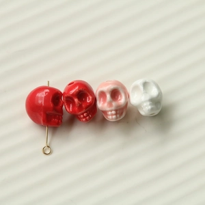 Macro view of colorful resin skull charms for jewelry making with metal pin detail