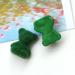 Detail of green flocked teddy bear DIY charm with smooth flat back and plush texture