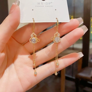 Detailed view of gold gourd earrings with sparkling zircon crystals and long tassels