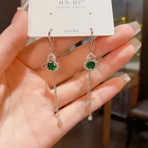 Detailed close-up of S925 silver butterfly tassel earrings with green gemstones