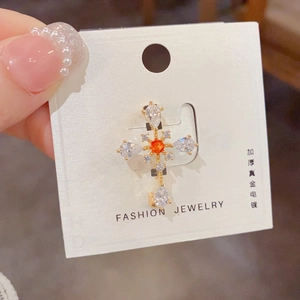 Detail of cross brooch with water drop zircons and premium gold plating finish