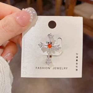 Cross brooch with water drop zircons and orange center stone in silver finish