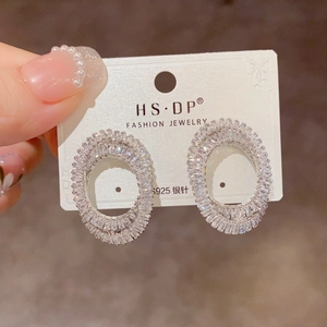 Gros plan de boucles d'oreilles ovales étincelantes avec cristaux et clou en argent S925