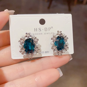 Macro detail of vintage floral earrings with blue gemstone and S925 silver needles