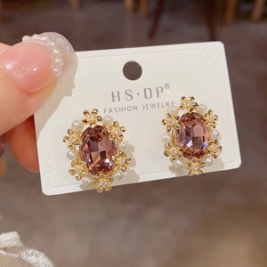 Detailed macro view of vintage lavender gemstone earrings with golden floral accents