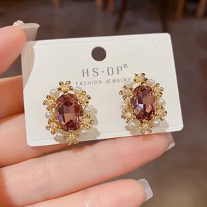 Detailed view of vintage gold petal earrings featuring brown crystals and white pearls