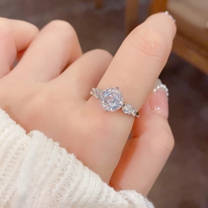 Macro shot of silver ring with large round zircon center stone and side accents