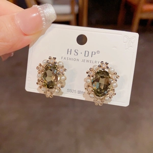 Vintage gold petal earrings with olive green gemstone and pearls on a display card