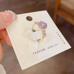 Macro shot of purple zircon flower ring with gold plating and sparkling side stones