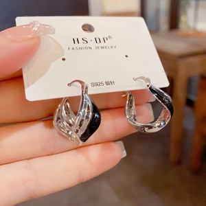 Detail of S925 silver needle drop earrings with silver and black twisted drip oil design