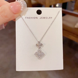 Macro view of silver clover pendant with white zircon pavé on a delicate O-chain