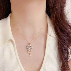 Collar de corazón vintage dorado con perlas y circonitas en gota puesto en modelo