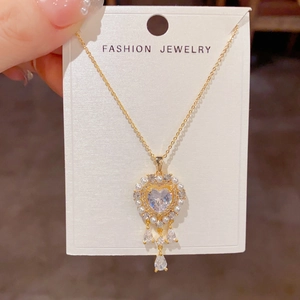 Primer plano del colgante de corazón dorado con perlas blancas y circonitas brillantes