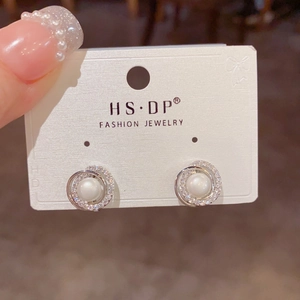 Elegante silberne Perlenohrringe mit glitzerndem Diamantrand auf Displaykarte