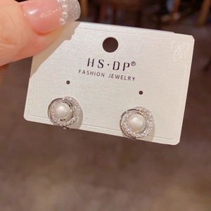 Detailansicht eleganter Perlenohrclips mit glitzerndem Diamantkranz in Silberoptik