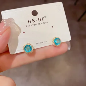 Vue détaillée des boucles d'oreilles fleur bleue avec tiges en argent S925