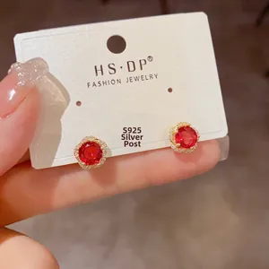 Détail de boucles d'oreilles en argent S925 avec pierres rouges et zircons brillants