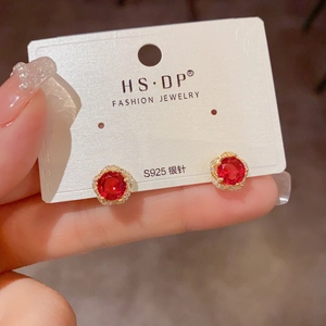 Gros plan sur boucle d'oreille fleur en argent S925 avec pierre rouge et zircons brillants