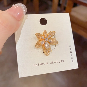 Détail macro d'une broche feuille avec pierres marquises pavées et placage en or