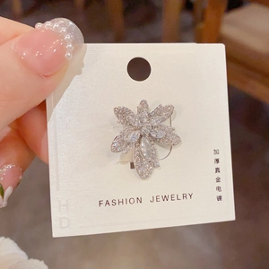 Détail de la broche feuille d'érable avec zircons et placage en or véritable épais