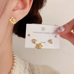 Detailsicht des dreiteiligen goldenen Blumen- und Herz-Ohrring-Sets mit S925 Silbersteckern