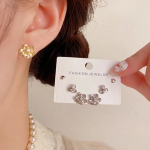 Detailansicht der Blumen-Ohrstecker mit Perlen und Kristallen am Ohr und auf der Karte