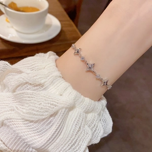 Detail of silver star bracelet with zircon stones worn by a model in a lifestyle setting