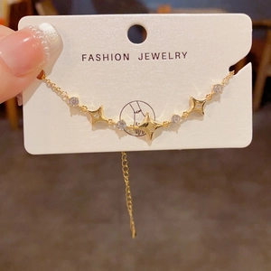 Detail showing gold star bracelet with cubic zirconia charms on white display card