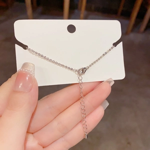 Detail of silver star bracelet featuring a lobster clasp and teardrop charm extender chain