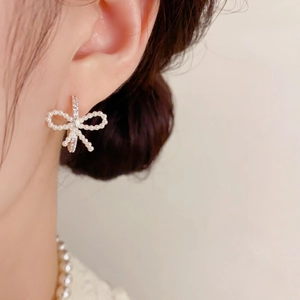 Pendientes de lazo plateados con perlas y circonitas en modelo para un look dulce